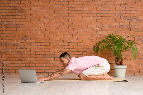 Young man with laptop doing...