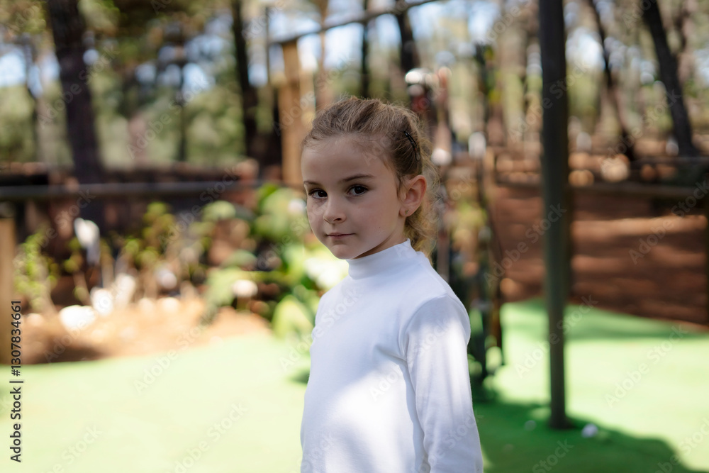 Young girl standing in park wearing white turtleneck Young girl standing in park wearing white turtleneck