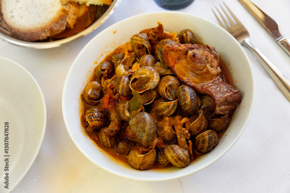Snails stewed with rabbit meat and sausage, spanish cuisine Snails stewed with rabbit meat and sausage, spanish cuisine