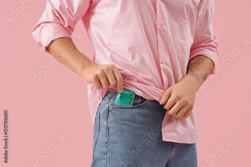 Young man putting condom in...