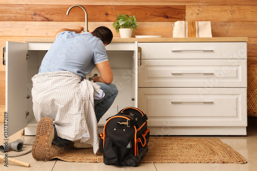 Male plumber fixing sink in...