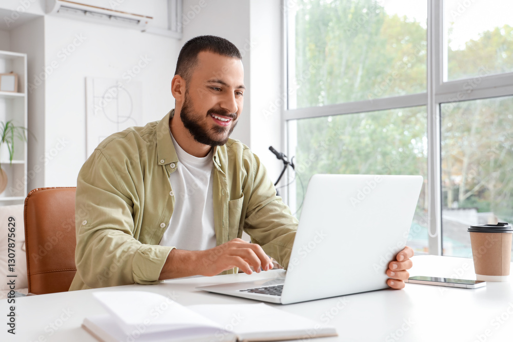 Handsome man working with laptop at home Handsome man working with laptop at home