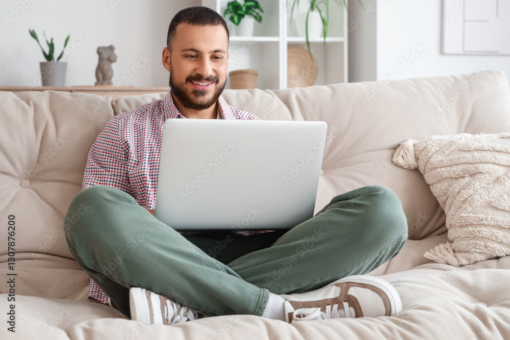 Freelancer sitting on sofa and using laptop at home Freelancer sitting on sofa and using laptop at home