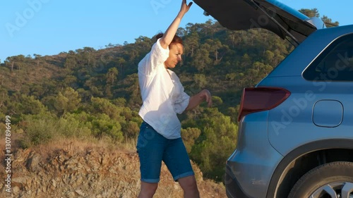 Wallpaper Mural Woman putting camping gear into car trunk. Woman prepares for a mountain hike on a sunny summer day, taking a camping chair out of her car trunk and organizing her gear for the adventure ahead Torontodigital.ca