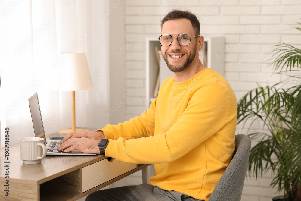 Young man sitting at workplace and working with laptop at home Young man sitting at workplace and working with laptop at home