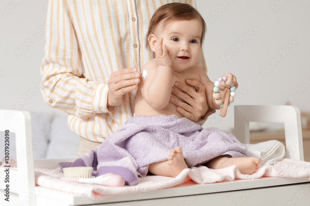 Fototapeta premium Mother applying cream on her little baby's hand on changing table in bedroom. Closeup