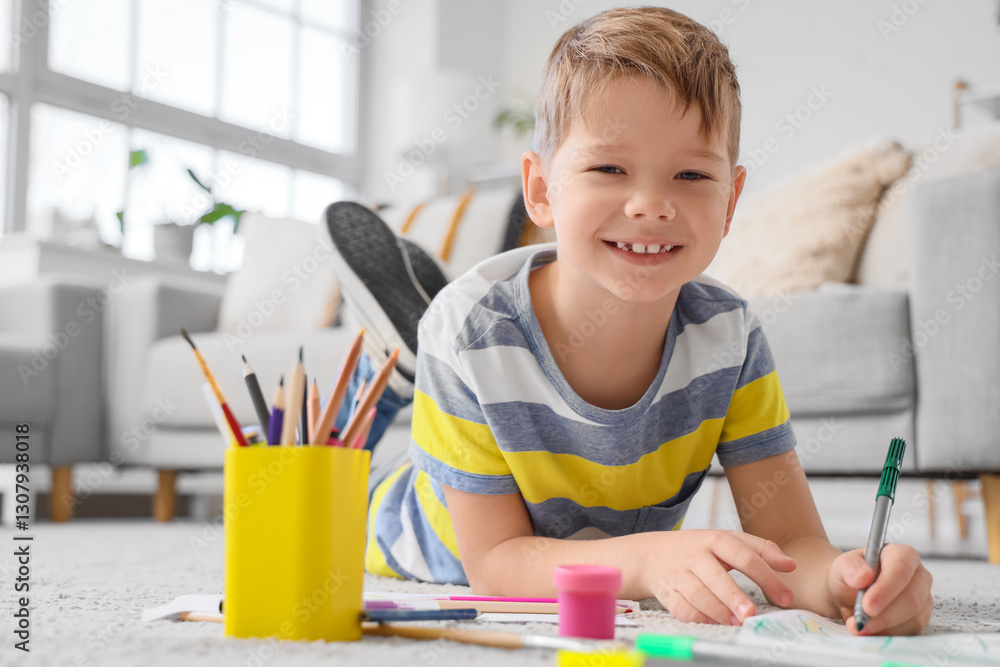 Smiling little boy drawing with felt-tip pens on floor at home Smiling little boy drawing with felt-tip pens on floor at home