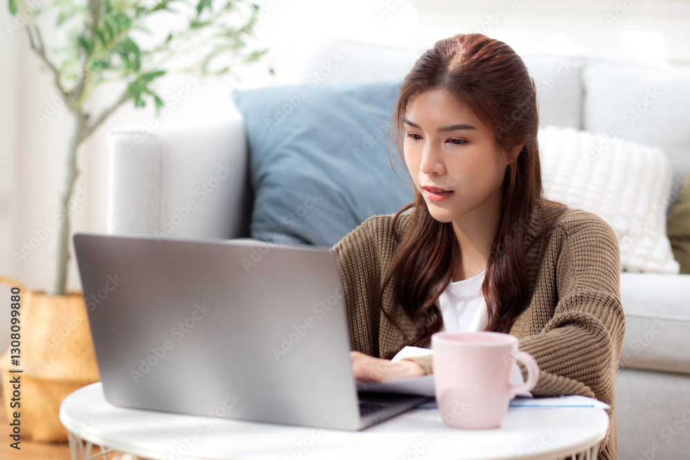 Young asian woman using laptop with happy and satisfaction in living room at home, woman relaxation with notebook computer or working from home, business browsing email, business and freelance. Young asian woman using laptop with happy and satisfaction in living room at home, woman relaxation with notebook computer or working from home, business browsing email, business and freelance.