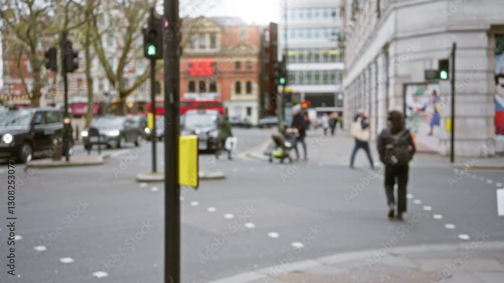 Blurry winter street scene in london showing people crossing with iconic red buses and city buildings in the background. Blurry winter street scene in london showing people crossing with iconic red buses and city buildings in the background.