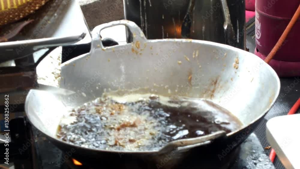A dynamic scene of fried chicken cooking in the pan, capturing a skillfully wok while busy kitchen preparing for a meal.
