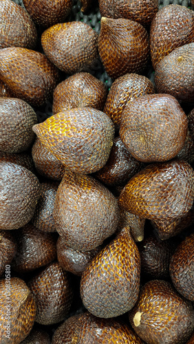 A pile of snake fruit on the shelf of a fruit shop