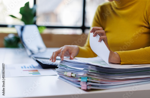 Фотография Business asian woman hands working in Stacks of paper files for searching and ch