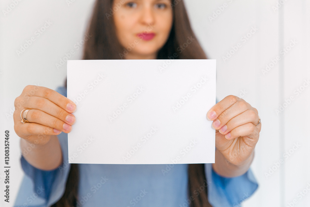 A young, attractive girl holding mockup with empty paper. A sign, an empty space for advertising, inscription, design. White background. A young, attractive girl holding mockup with empty paper. A sign, an empty space for advertising, inscription, design. White background.