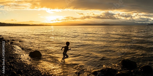 Silhouetted child running into ocean at sunset.