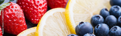 Vibrant Summer Fruit Mix: A close-up shot of a colorful assortment of fresh fruits including juicy strawberries, ripe blueberries, and zesty lemon slices.