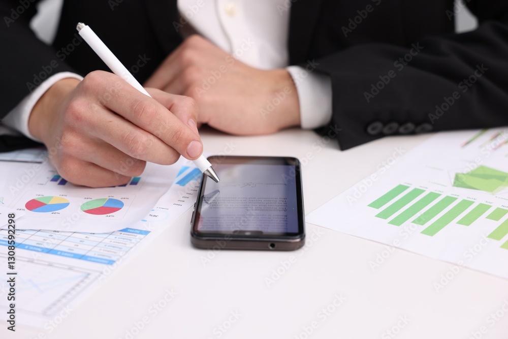 Electronic signature. Man using stylus and smartphone at white table, closeup Electronic signature. Man using stylus and smartphone at white table, closeup