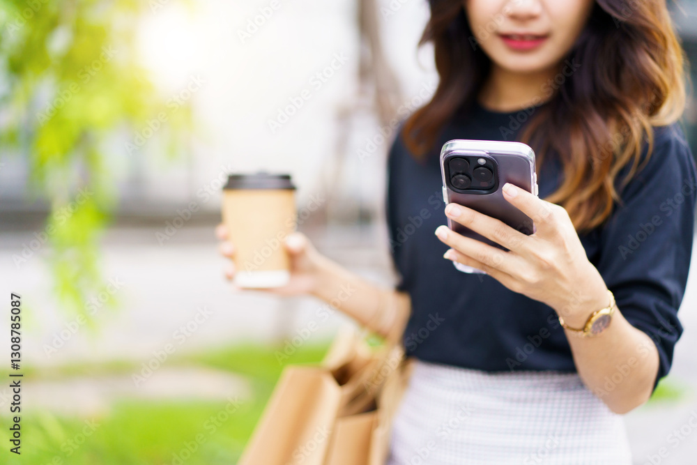Asian woman walking on the street with carry a shopping bag and coffee cup. Asian woman walking on the street with carry a shopping bag and coffee cup.