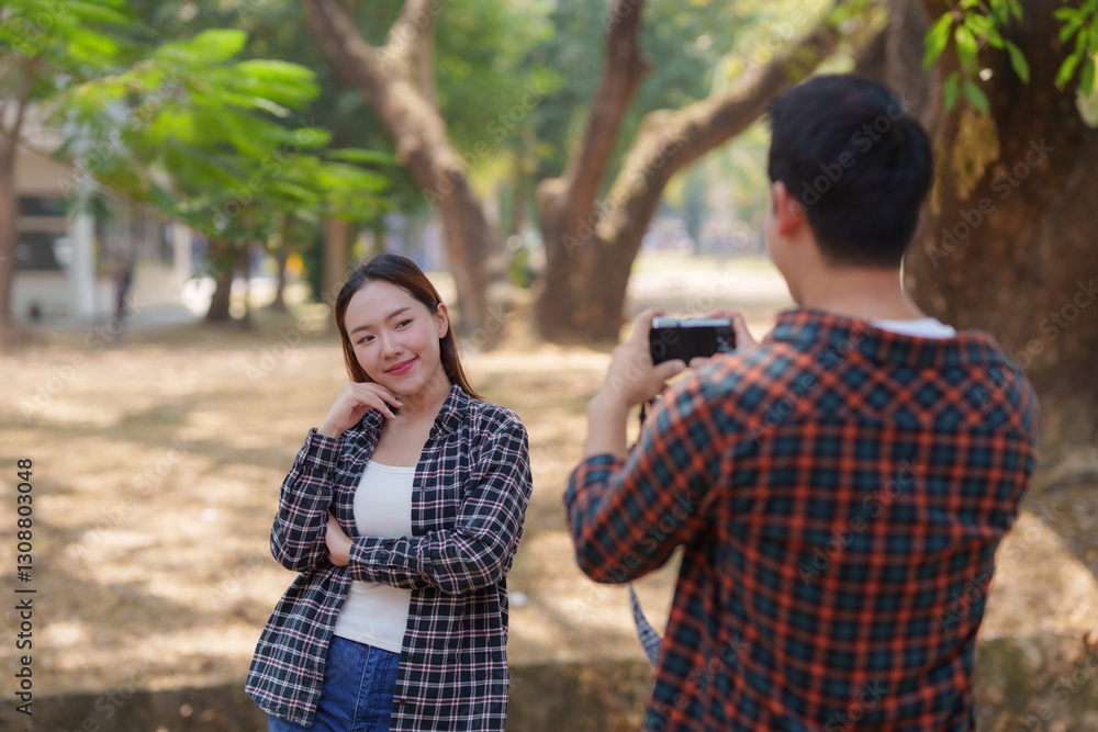 Photographer taking pictures of young woman in park Photographer taking pictures of young woman in park