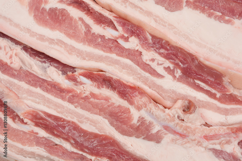A close-up, top-down view of thick cuts of raw pork belly, showcasing the distinct layers of fat and meat A close-up, top-down view of thick cuts of raw pork belly, showcasing the distinct layers of fat and meat