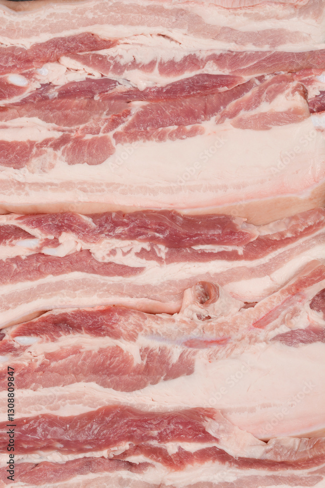 A close-up, top-down view of thick cuts of raw pork belly, showcasing the distinct layers of fat and meat A close-up, top-down view of thick cuts of raw pork belly, showcasing the distinct layers of fat and meat