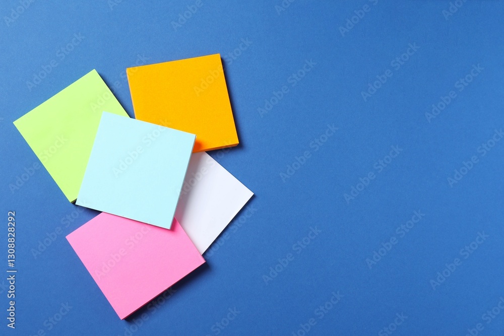 Multicolored paper stickers on a blue background Multicolored paper stickers on a blue background