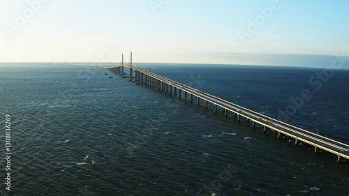 Wallpaper Mural Sunshine Skyway Bridge stretches over deep blue waters under the morning sun. The aerial perspective highlights the bridge’s elegant design and its connection across Tampa Bay. Torontodigital.ca