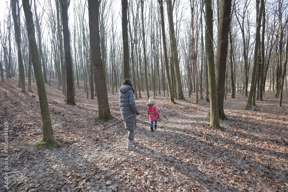 Fototapeta premium Woman and a kid walking in the forest