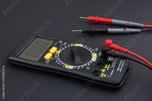 Digital multimeter with probes and display on dark background. photo