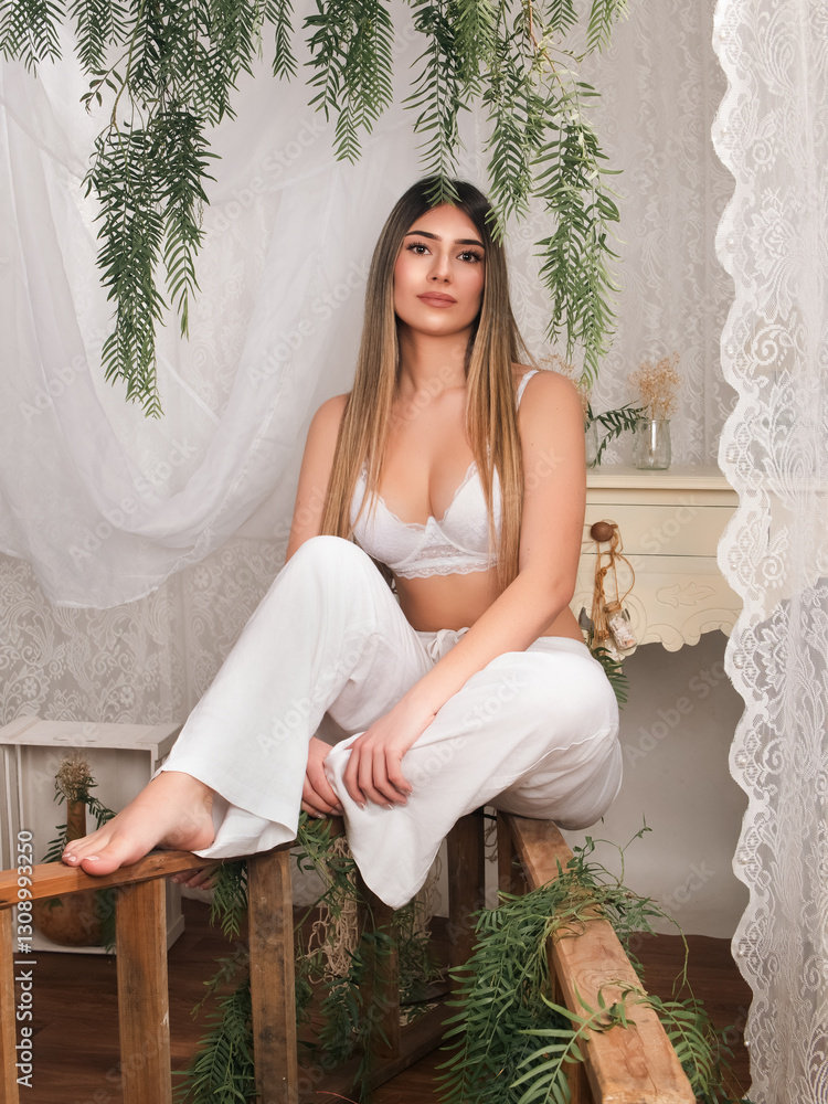 Fototapeta premium Woman in White Attire Poses Elegantly in a Beautifully Decorated Indoor Space With Greenery and Vintage Furniture