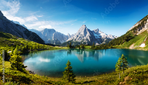 Mountain Lake Vista: An awe-inspiring panorama unfolds, revealing a pristine mountain lake cradled by majestic peaks under a brilliant azure sky.