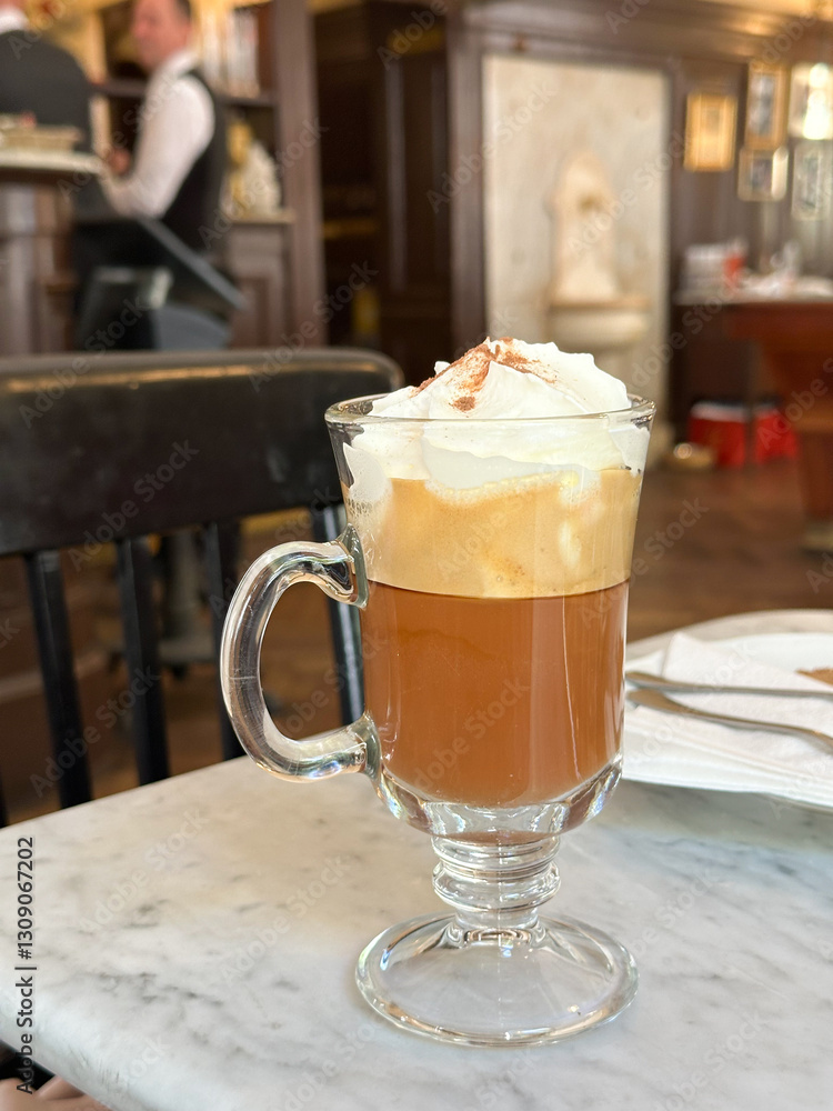 Coffee Maria Theresia with whipped cream and a sprinkle of cinnamon on top in a glass mu Coffee Maria Theresia with whipped cream and a sprinkle of cinnamon on top in a glass mu