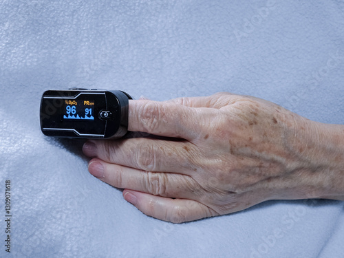 Картината върху платно Senior woman patient wearing fingertip pulse oximeter device during medical exam