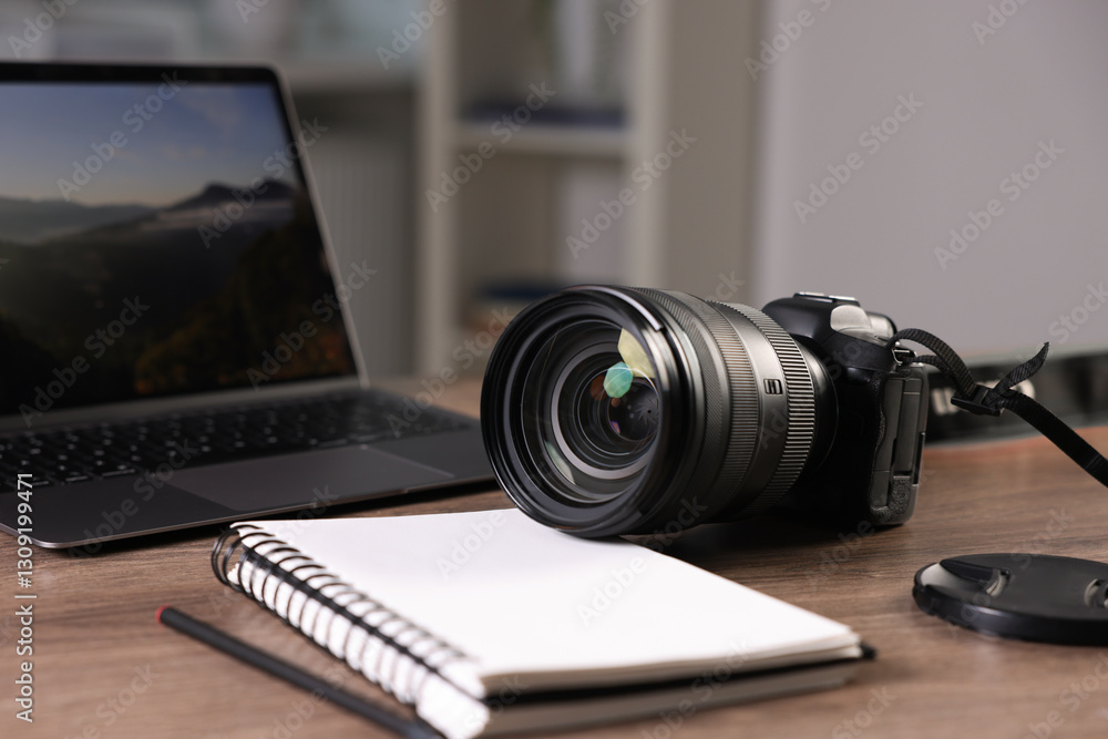 Professional photo camera, laptop and notepad on wooden desk indoors, closeup Professional photo camera, laptop and notepad on wooden desk indoors, closeup