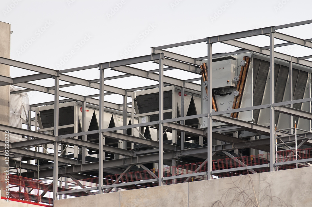 concrete building and metal beam frame during construction against grey sky concrete building and metal beam frame during construction against grey sky