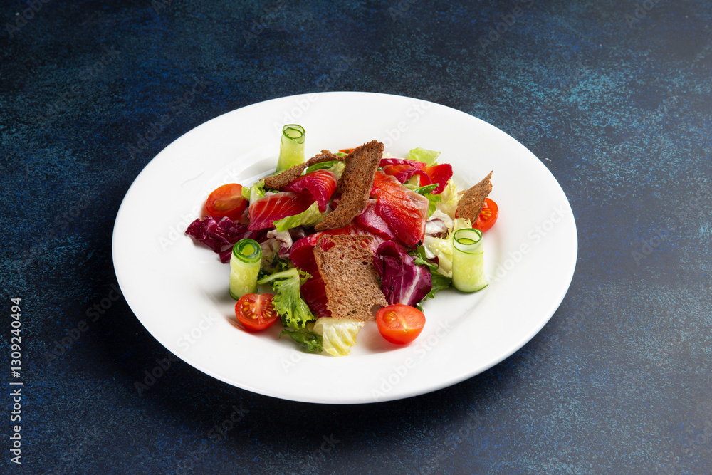Salad with salmon in a plate on a dark background. Salad with salmon in a plate on a dark background.
