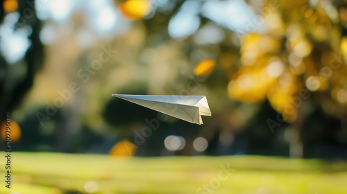 Paper Airplane Soaring Through Autumnal Park Scene