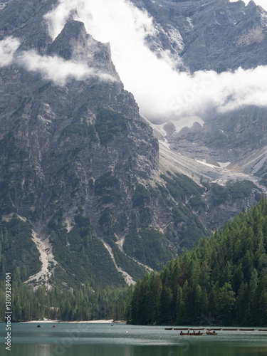 Lago al pie de una montaña con nubes atravesando la montaña
