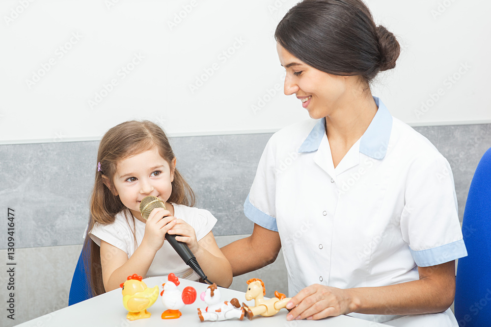 A child practices speech skills during a therapy session with a friendly therapist, using a microphone and various toys for support A child practices speech skills during a therapy session with a friendly therapist, using a microphone and various toys for support