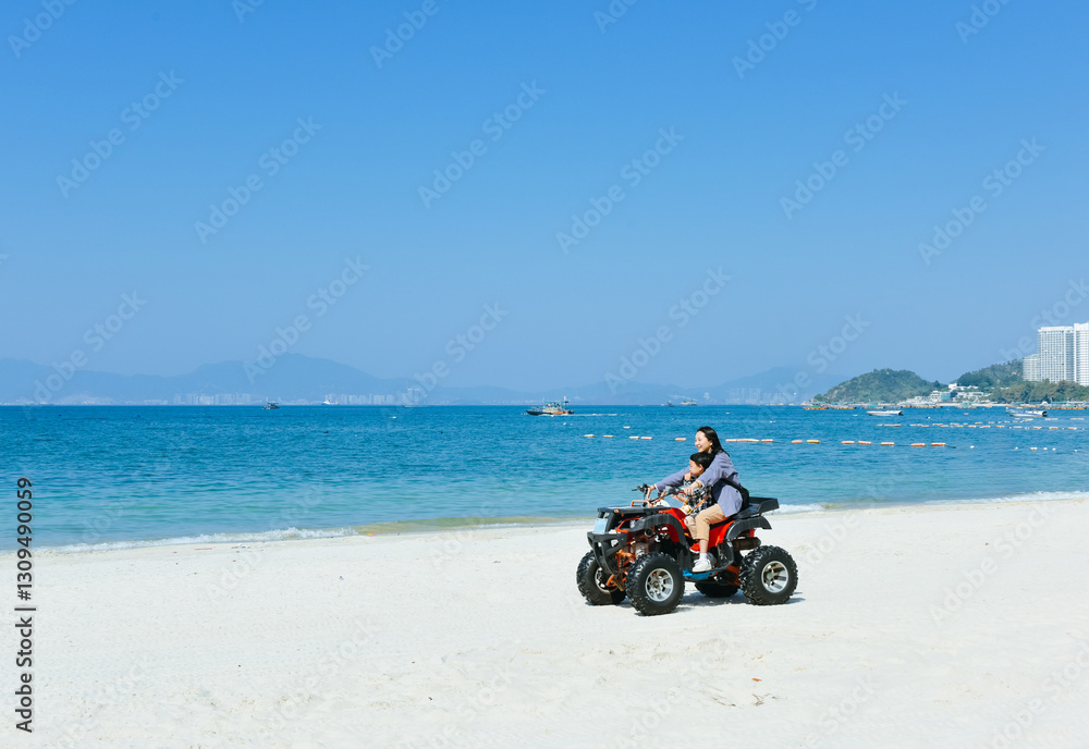 Obraz premium Asian kid and mom riding ATV at in Xunliao Bay, Huizhou city, Guangdong Province, China, during January