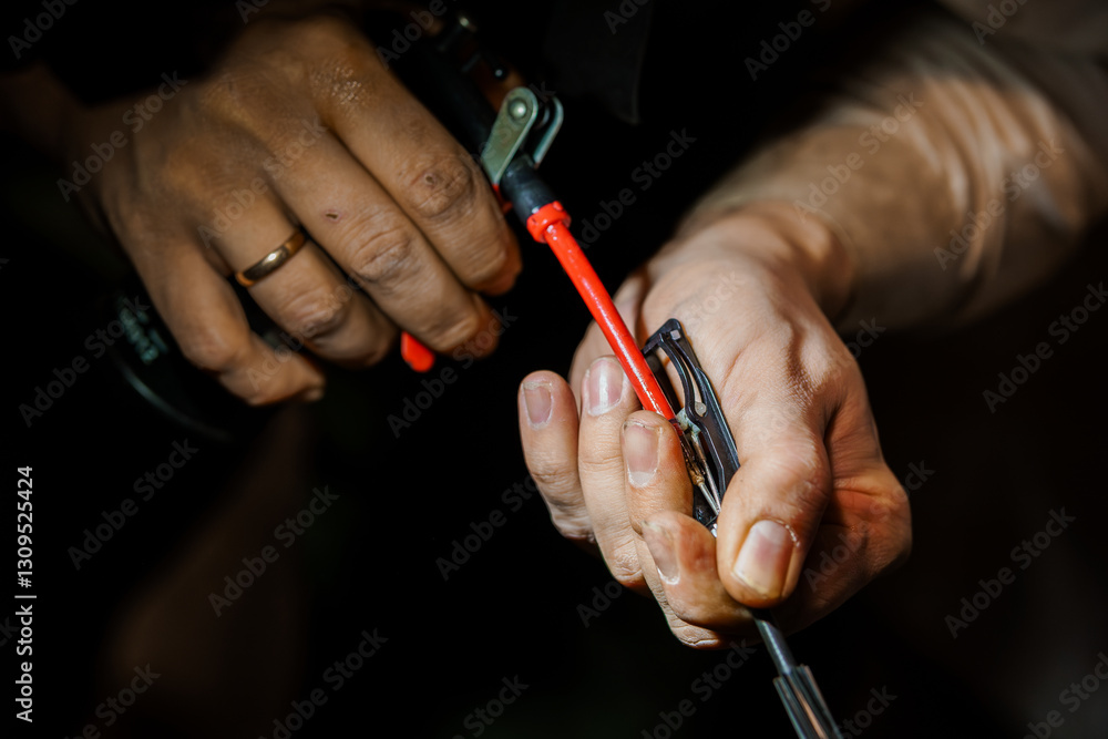 Expert Hands Performing Precision Craftsmanship in a Dimly Lit Workshop Expert Hands Performing Precision Craftsmanship in a Dimly Lit Workshop