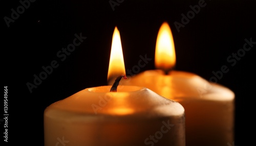 two burning candles in the dark