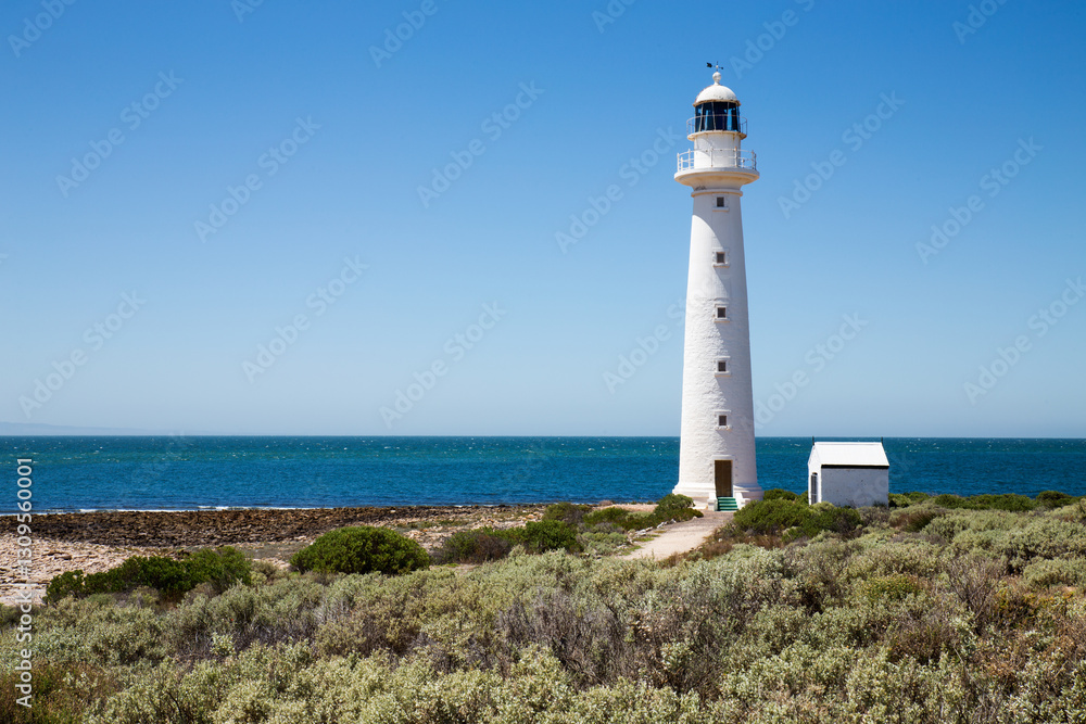 lighthouse with blue water and cloudless sky lighthouse with blue water and cloudless sky