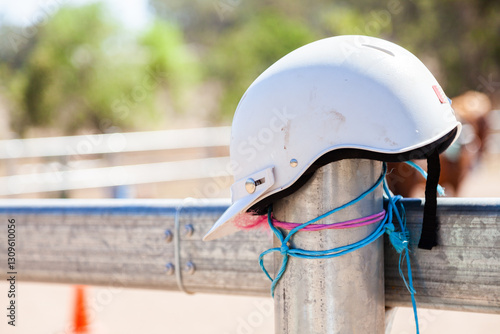 Horse riding helmet on metal yard fence photo