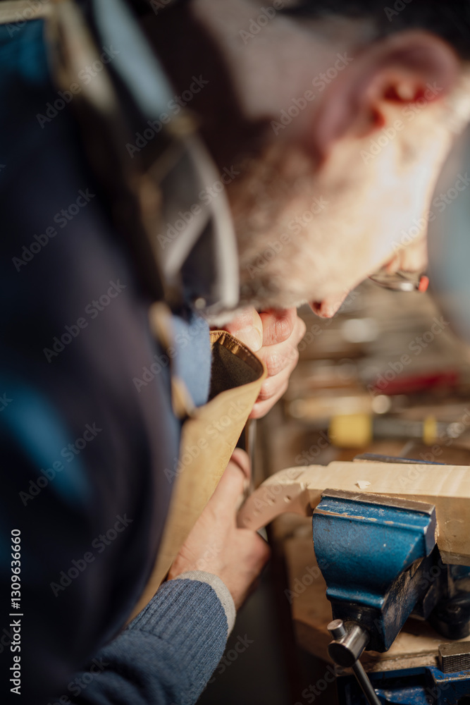 Obraz premium Luthier carefully working on violin scroll in workshop