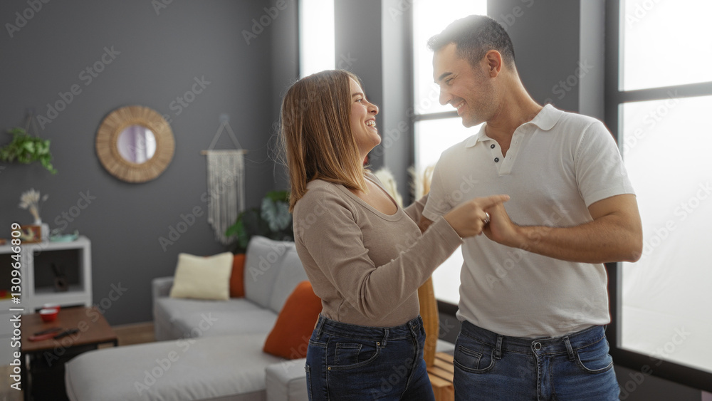 Hispanic couple smiling and dancing together in cozy living room filled with natural light, showcasing their love and joyful relationship indoors. Hispanic couple smiling and dancing together in cozy living room filled with natural light, showcasing their love and joyful relationship indoors.