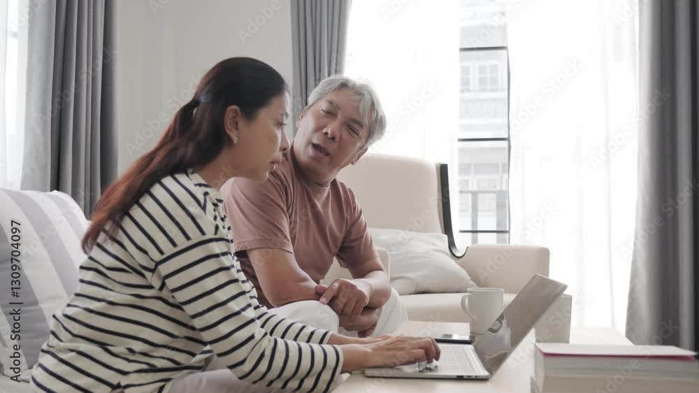 Senior Asian couple working with notebook at home. Senior Asian couple working with notebook at home.