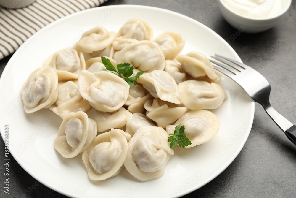 Delicious dumplings with fresh parsley served on grey table, closeup Delicious dumplings with fresh parsley served on grey table, closeup