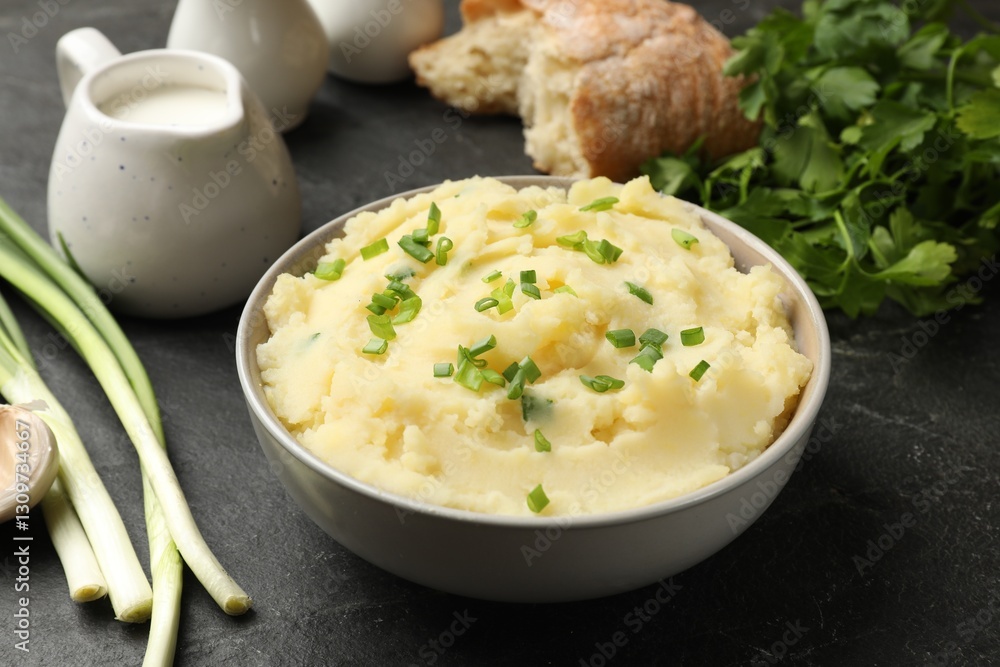 Delicious mashed potato with green onions served on black table, closeup Delicious mashed potato with green onions served on black table, closeup