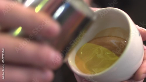 Barista’s hand creating an intricate swan latte art design in a cup of coffee. Close-up shot capturing the precision and skill of coffee artistry in a professional café setting.