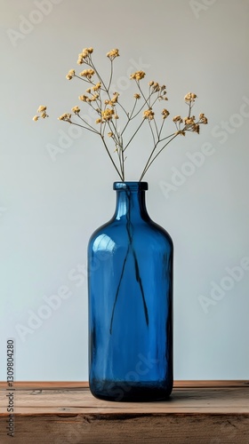 Vintage Blue Glass Bottle With Cork Stopper on Wooden Table Against Cloudy Ba...